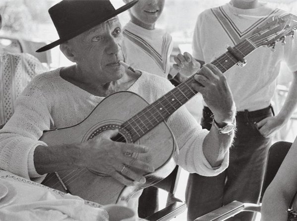 image : photographie Picasso jouant de la guitarre